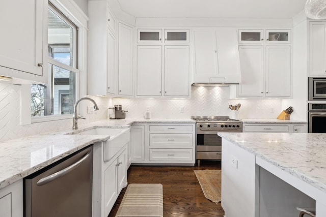 kitchen featuring appliances with stainless steel finishes, a sink, glass insert cabinets, and white cabinets