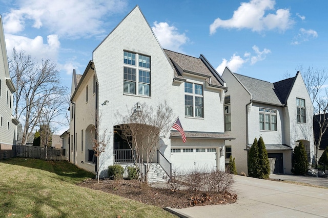 view of front facade featuring driveway, an attached garage, fence, a front lawn, and brick siding