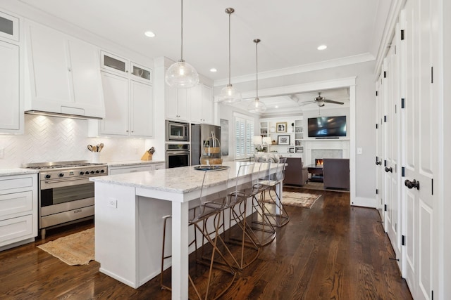 kitchen with a breakfast bar area, stainless steel appliances, dark wood-style flooring, open floor plan, and glass insert cabinets