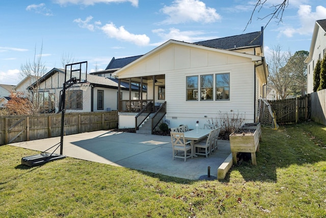 back of house with board and batten siding, a ceiling fan, a lawn, and a patio