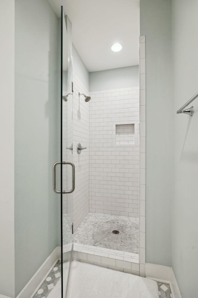 full bath featuring a stall shower and baseboards