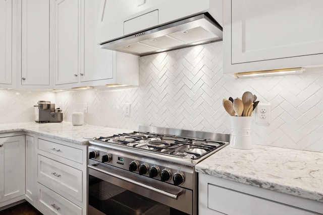 kitchen featuring tasteful backsplash, light stone countertops, high end range, and extractor fan