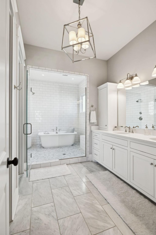 full bath featuring a freestanding tub, a shower stall, marble finish floor, and vanity