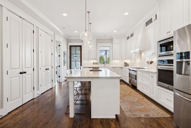 kitchen with stainless steel appliances, ornamental molding, glass insert cabinets, and light stone countertops