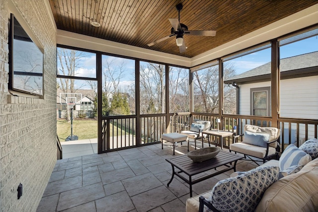 sunroom featuring wooden ceiling and a ceiling fan