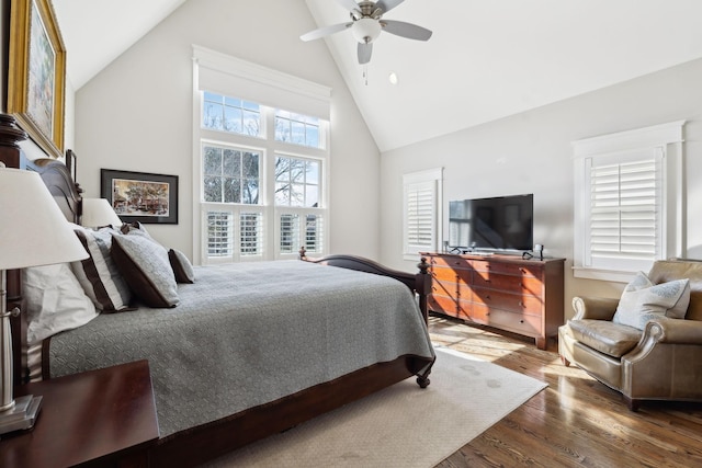 bedroom with ceiling fan, high vaulted ceiling, and wood finished floors