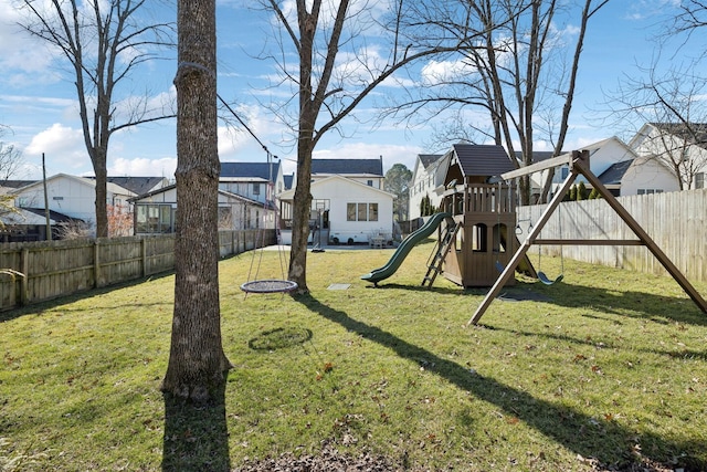 view of jungle gym with a residential view, a fenced backyard, and a lawn