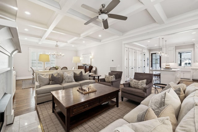 living room featuring recessed lighting, beam ceiling, coffered ceiling, and ceiling fan with notable chandelier