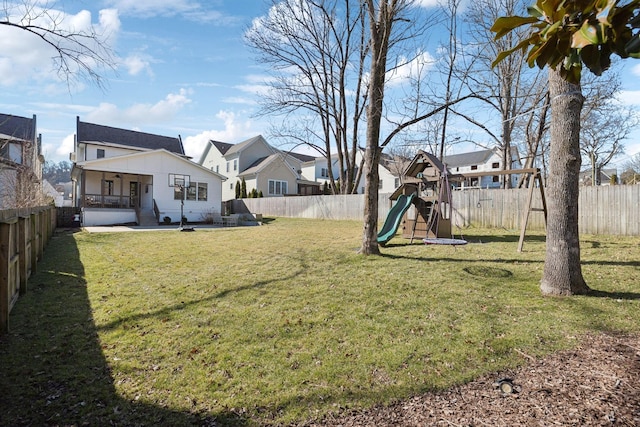 view of yard featuring a patio area, a fenced backyard, and a playground