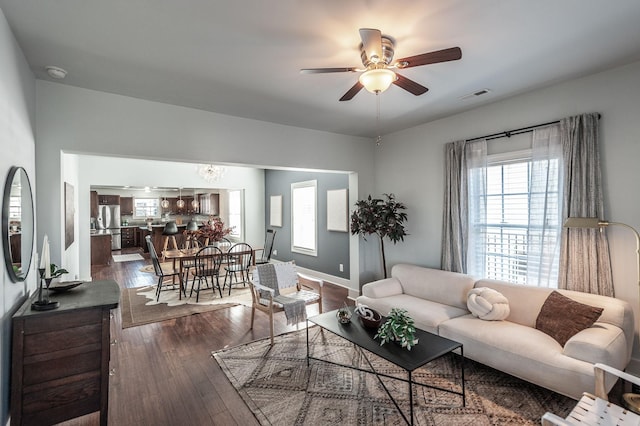 living area with ceiling fan, visible vents, baseboards, and dark wood-style floors