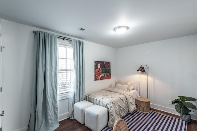 bedroom with dark wood-type flooring, baseboards, and visible vents