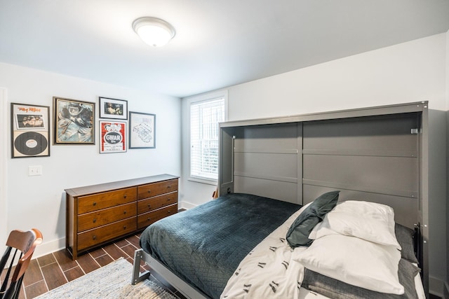 bedroom featuring wood finish floors and baseboards