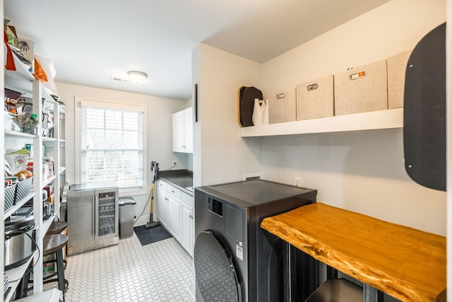 laundry area with beverage cooler, cabinet space, and washer / clothes dryer