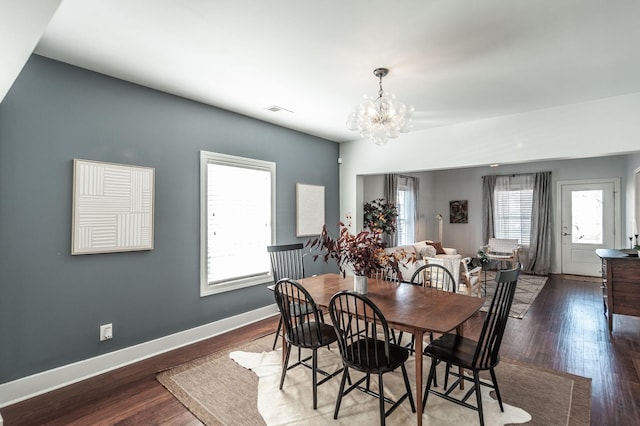 dining room with visible vents, an inviting chandelier, baseboards, and wood finished floors