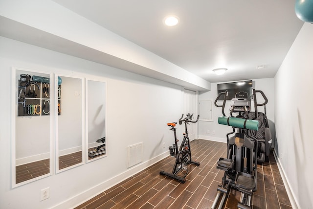 workout area featuring visible vents, baseboards, and wood tiled floor