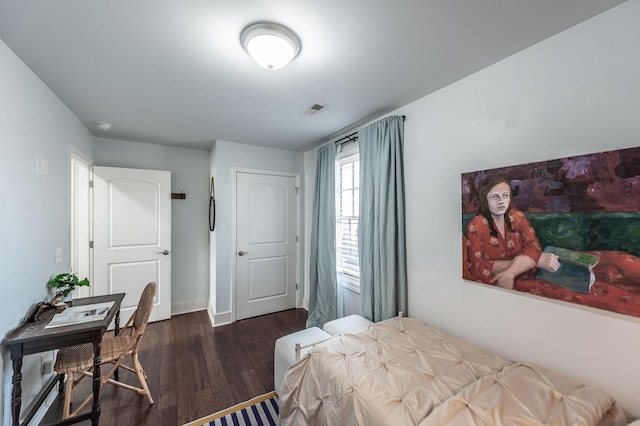 bedroom featuring visible vents, baseboards, and wood finished floors