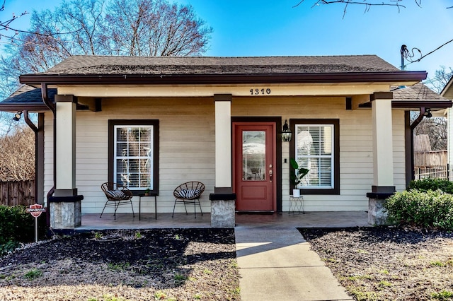 entrance to property with a porch and fence