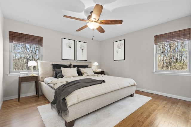 bedroom featuring light wood-style floors, ceiling fan, and baseboards