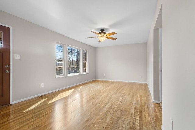 interior space with light wood-style floors, visible vents, baseboards, and a ceiling fan