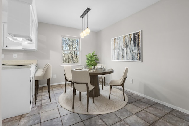 dining area featuring a notable chandelier and baseboards