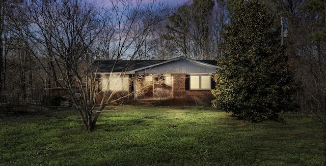 view of side of property with a lawn and brick siding