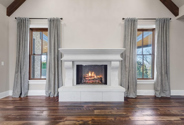 room details featuring wood finished floors, baseboards, and a warm lit fireplace