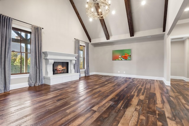 unfurnished living room featuring beam ceiling, high vaulted ceiling, wood-type flooring, and a lit fireplace