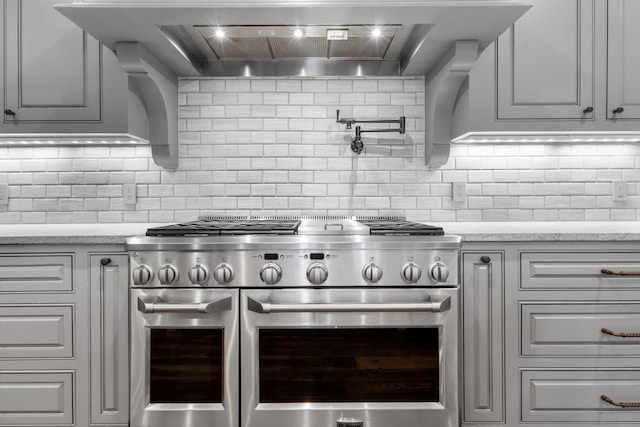 kitchen with range with two ovens, tasteful backsplash, and custom exhaust hood