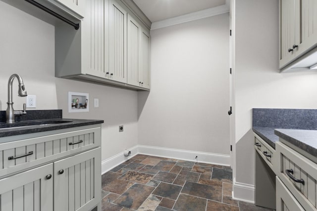 washroom featuring baseboards, electric dryer hookup, washer hookup, a sink, and stone finish flooring