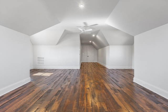 additional living space with visible vents, baseboards, vaulted ceiling, a ceiling fan, and dark wood-style flooring