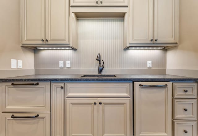 kitchen with cream cabinetry and a sink