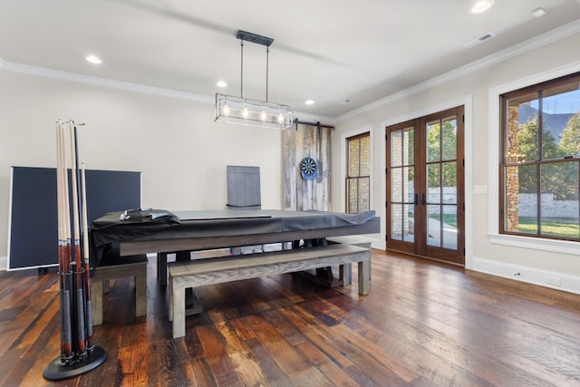 dining space featuring visible vents, ornamental molding, wood finished floors, french doors, and a barn door