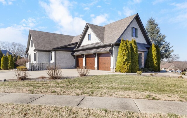 view of front facade with brick siding, a front yard, roof with shingles, and driveway