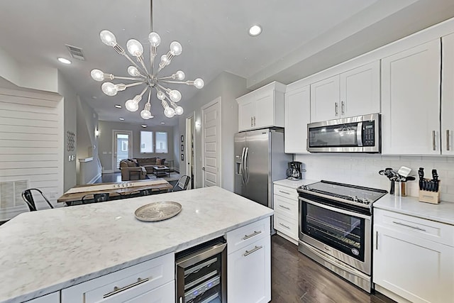 kitchen with wine cooler, stainless steel appliances, tasteful backsplash, visible vents, and open floor plan