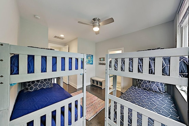 bedroom featuring baseboards, wood finished floors, visible vents, and a ceiling fan