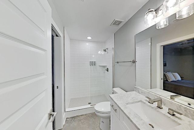 ensuite bathroom featuring toilet, visible vents, tiled shower, and vanity