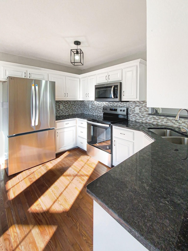 1173 Snoopy Dr, Clarksville, TN 37040 - kitchen featuring dark wood-style floors, decorative backsplash, appliances with stainless steel finishes, white cabinets, and a sink