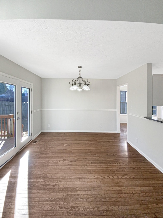 1173 Snoopy Dr, Clarksville, TN 37040 - unfurnished room with a chandelier, a textured ceiling, dark wood-style floors, and a wealth of natural light