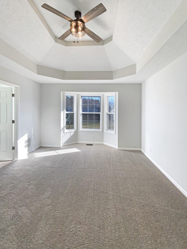 1173 Snoopy Dr, Clarksville, TN 37040 - spare room featuring a tray ceiling, carpet, ceiling fan, a textured ceiling, and baseboards