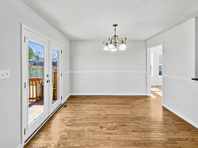 1173 Snoopy Dr, Clarksville, TN 37040 - unfurnished dining area with french doors, baseboards, an inviting chandelier, and wood finished floors