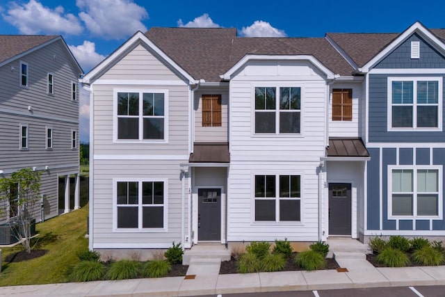 townhome / multi-family property with a shingled roof, a standing seam roof, and metal roof