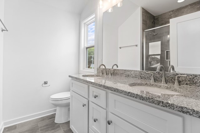 bathroom featuring double vanity, a sink, toilet, and a shower stall