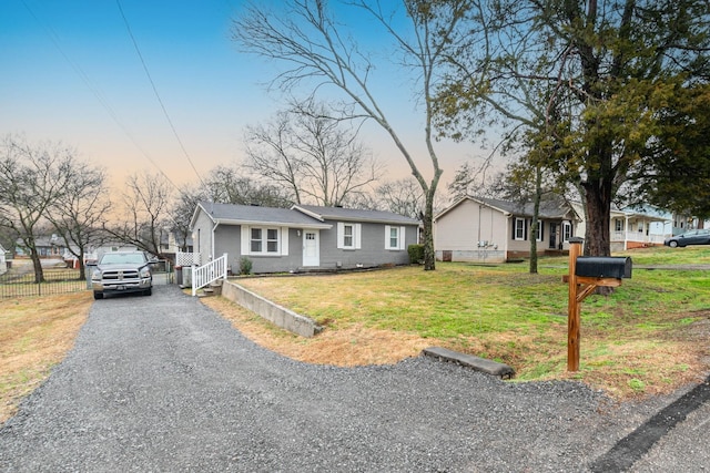 view of front of property with driveway, a front lawn, and fence