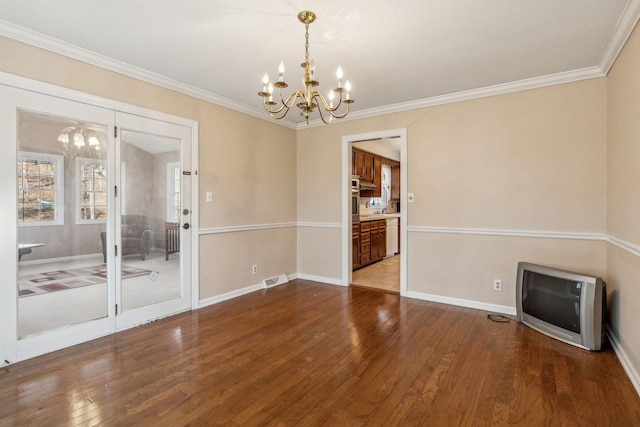 unfurnished dining area featuring crown molding, hardwood / wood-style flooring, and a notable chandelier