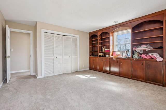 unfurnished bedroom with baseboards, a closet, visible vents, and light colored carpet