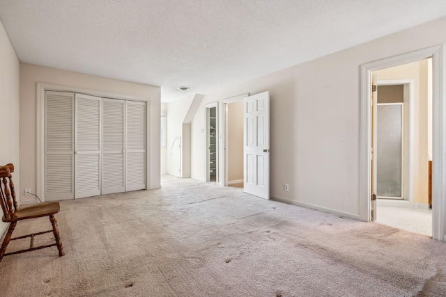 carpeted bedroom featuring a closet, baseboards, and a textured ceiling