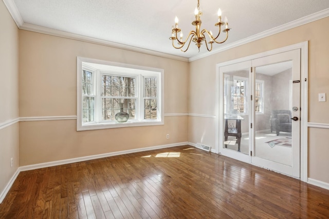 spare room featuring baseboards, visible vents, hardwood / wood-style floors, and ornamental molding