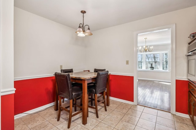 tiled dining room with baseboards and an inviting chandelier