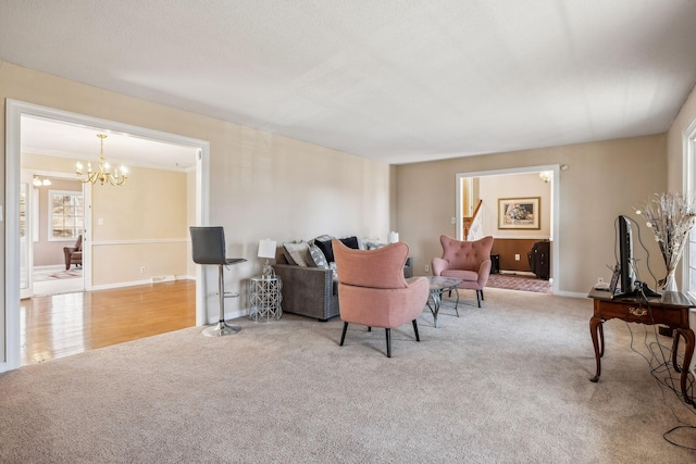 living area featuring a chandelier, carpet flooring, and baseboards