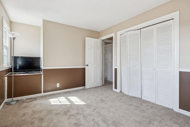 unfurnished bedroom featuring a closet, carpet flooring, and baseboards